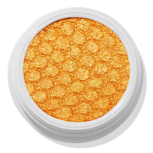 Montecito Super Shock Shadow by ColourPop shimmering in a bold metallic marigold-gold pan, embossed with a honeycomb texture, set in a round white pot against a clean white background.